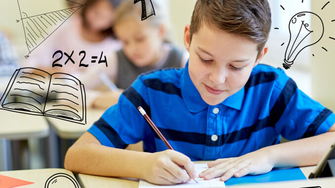 group of school kids writing test in classroom